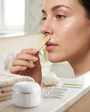 Mujer aplicando cera en el labio superior